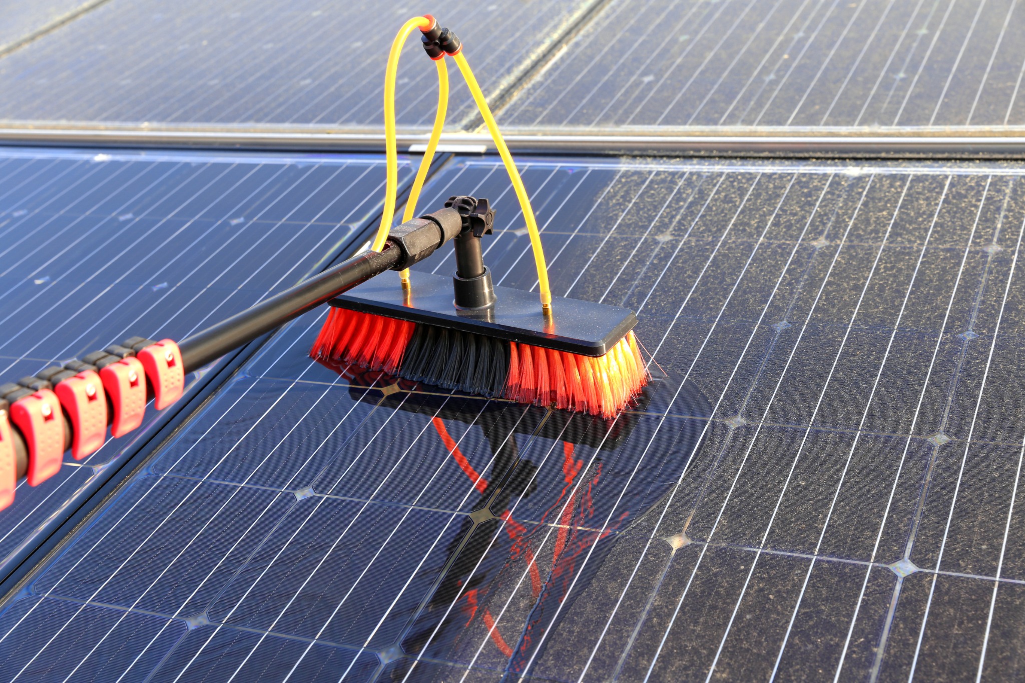 Illustrative photo of a brush cleaning a solar panel